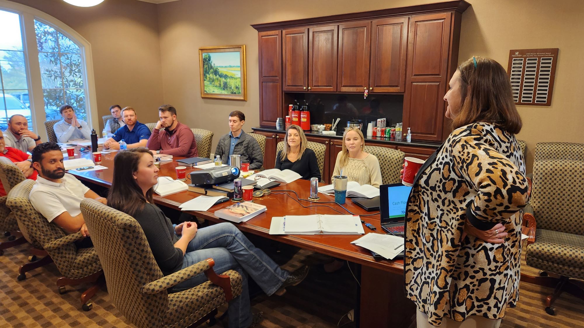 group of people around a conference table with speaker standing. 