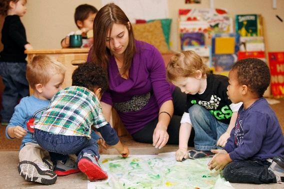 Children playing in the classroom with the teacher.